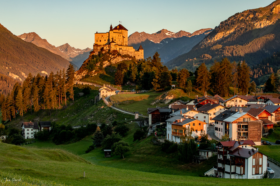Schloss Tarasp in goldener Sommerlicht-Stimmung umgeben von Alpenwäldern und Bergen der Schweiz – Jan Geerk Fotograf Basel