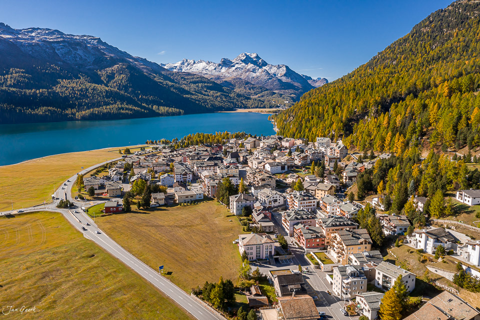 Luftaufnahme Silvaplana mit türkisblauem See, schneebedeckten Bergen und Lärchenwäldern im Herbst Engadin Schweiz – Jan Geerk Fotograf Basel