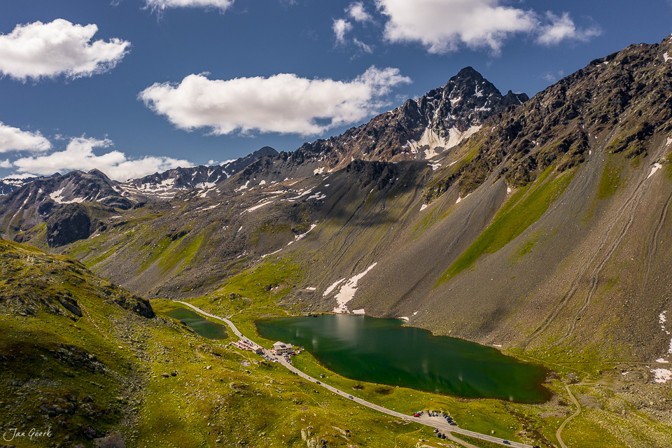 Alpiner See am Flüelapass mit grünen Wiesen, schroffem Bergpanorama und blauem Sommerhimmel – Graubünden Schweiz Jan Geerk Fotograf Basel