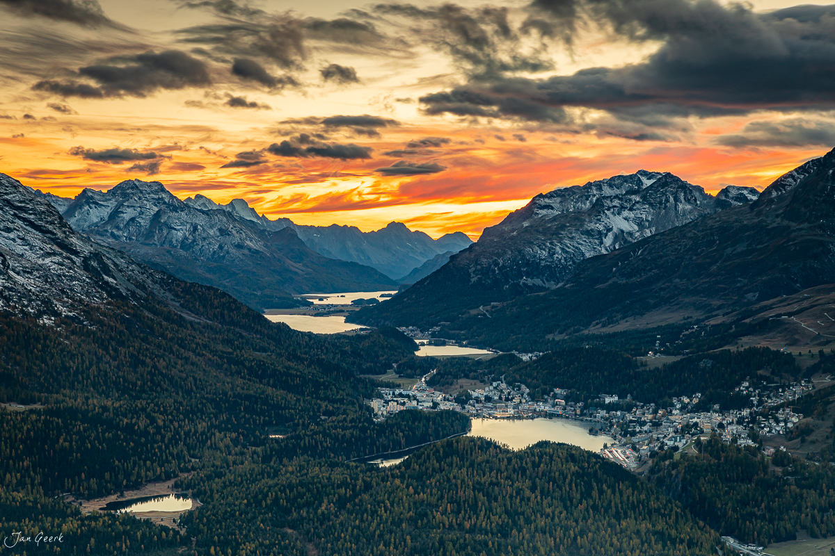 Alpensee bei Sonnenuntergang mit schneebedeckten Bergen, Wäldern und Dorf in Graubünden Schweiz – Jan Geerk Fotograf Basel