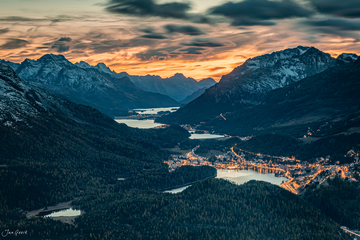 Alpental mit beleuchteter Stadt und Seen bei Sonnenuntergang Graubünden Schweiz – Jan Geerk Fotograf Basel