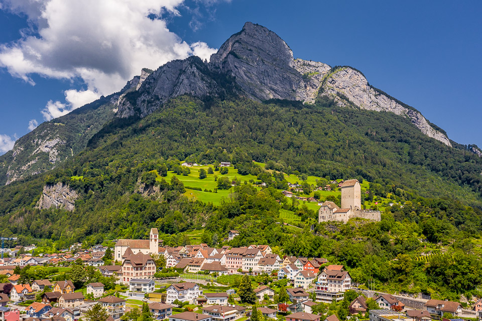 Schloss Sarganserland mit Bergpanorama, Alpengipfel und Ortschaft im Sommergrün, Graubünden Schweiz – Jan Geerk Fotograf Basel