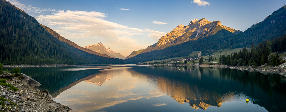 Bergsee Sufers mit Spiegelung der Alpengipfel bei Sonnenlicht, Graubünden Schweiz – Jan Geerk Fotograf Basel
