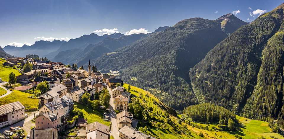 Luftaufnahme des Dorfes Guarda mit Bergpanorama im Sommer, Unterengadin Graubünden Schweiz – Jan Geerk Fotograf Basel