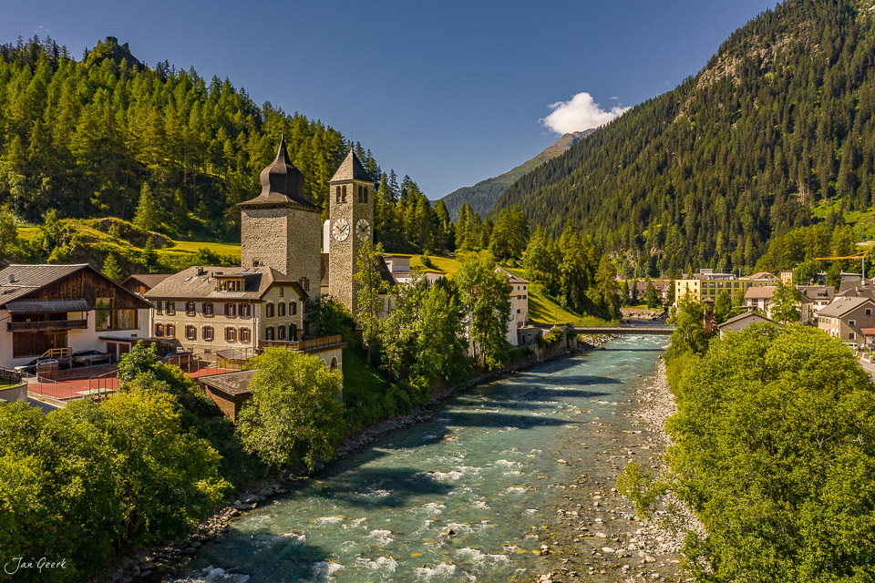 Dorfkirche Susch mit Kirchturm am türkisgrünen Inn, umgeben von Lärchenwald im Unterengadin, Sommer in Graubünden Schweiz – Jan Geerk Fotograf Basel