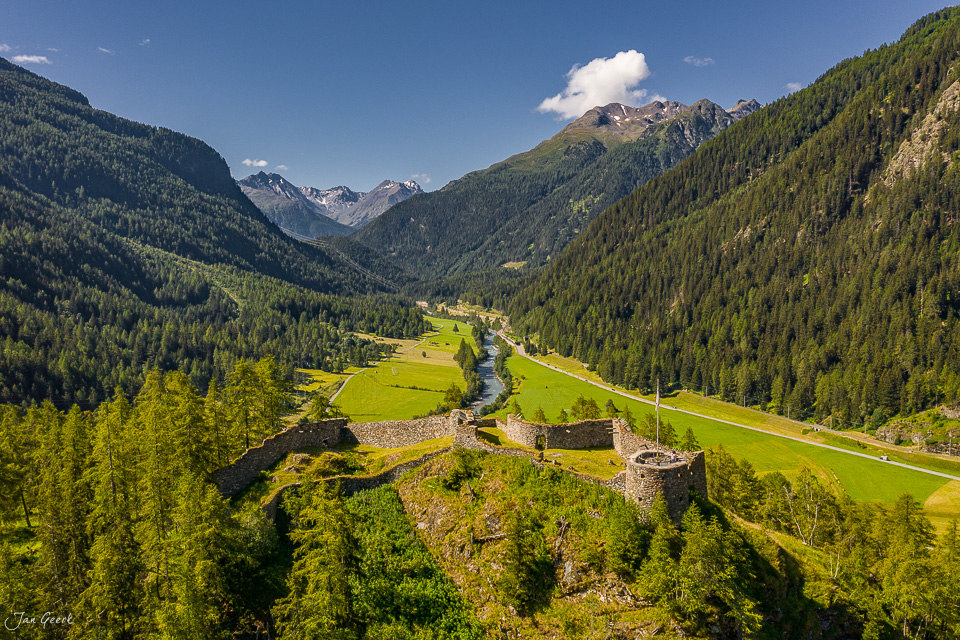 Burgruine Tarasp im Unterengadin mit grüner Berglandschaft und Koniferen im Sommer in Graubünden Schweiz – Jan Geerk Fotograf Basel