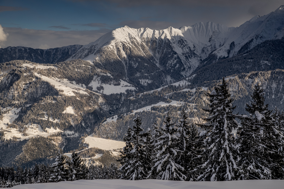 Schneebedeckte Berglandschaft Laax mit verschneiten Tannen und Alpengipfel im Winter Graubünden Schweiz Jan Geerk Fotograf Basel