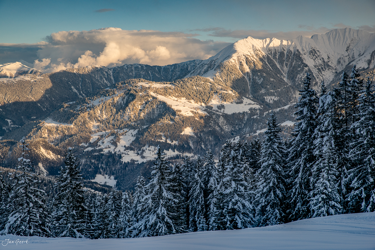 Schneebedeckte Berglandschaft Laax mit verschneiten Fichten, Alpengipfeln und Winterlicht, Graubünden Schweiz – Jan Geerk Fotograf Basel