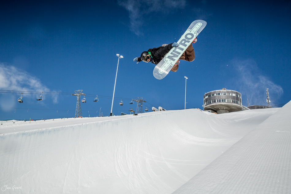 Snowboarder in der Halfpipe Laax vor Bergkulisse und Sessel, sonniger Wintertag Graubünden Schweiz – Jan Geerk Fotograf Basel