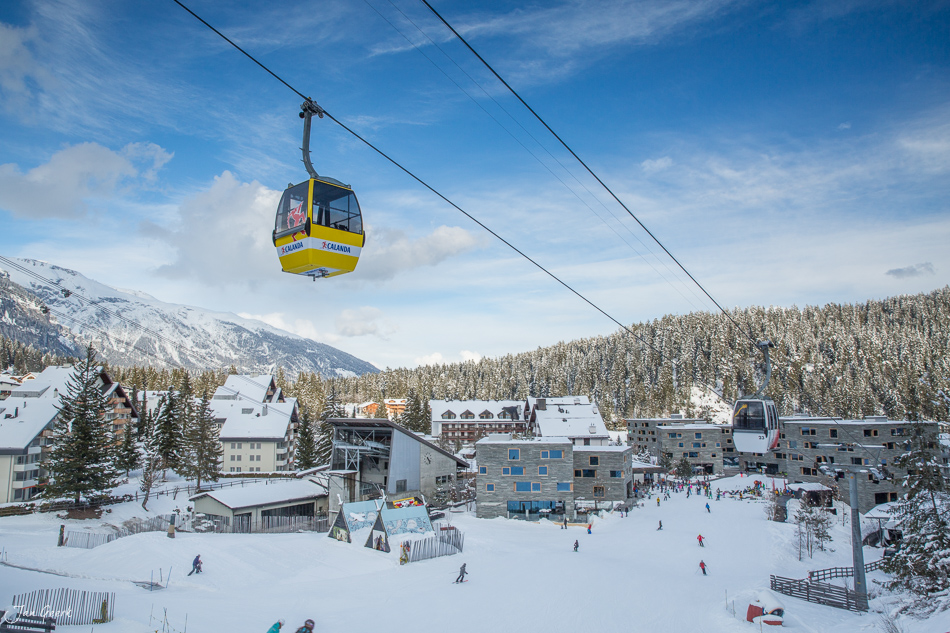 Gelbe Luftseilbahn über schneebedecktem Skigebiet Laax mit Hotels und Pisten im Winter in Graubünden Schweiz von Jan Geerk Fotograf Basel