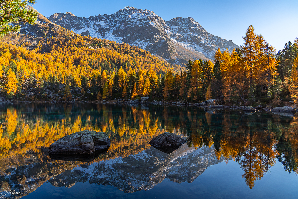 Spiegelglatter Bergsee mit goldenen Lärchen im Herbst bei Lago di Saoseo Graubünden Schweiz Jan Geerk Fotograf Basel