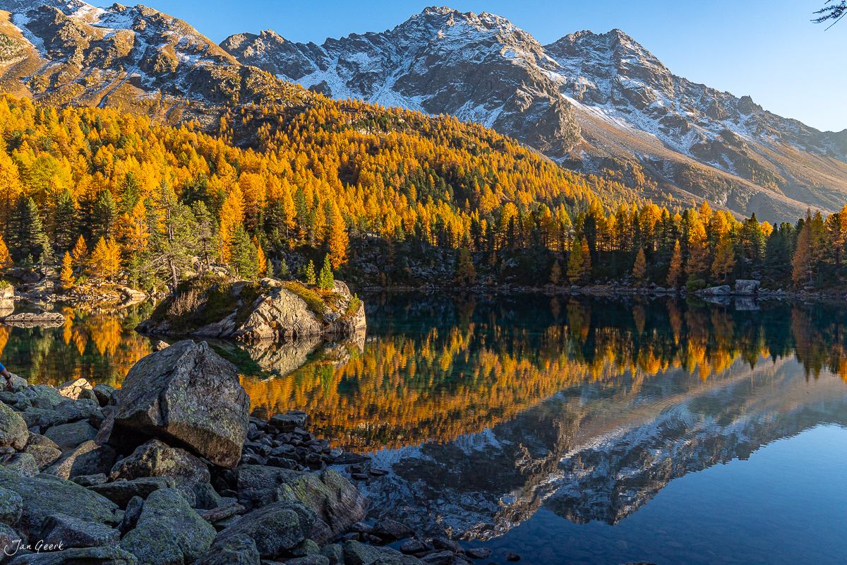 Alpensee Lago di Saoseo mit goldenen Lärchen, schneebedeckten Bergen und Spiegelung im Herbst, Graubünden Schweiz – Jan Geerk Fotograf Basel