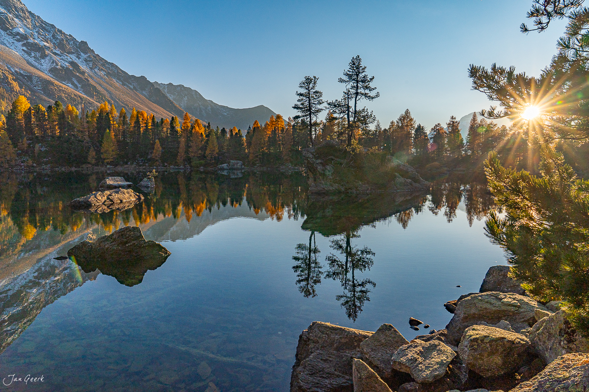 Spiegelglatter Bergsee mit Lärchenwäldern im Herbstlicht am Lago di Saoseo Graubünden Schweiz – Jan Geerk Fotograf Basel