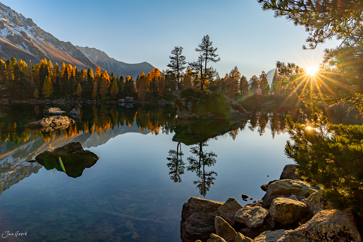 Spiegelglatter Bergsee Lago di Saoseo mit herbstlichen Lärchen im goldenen Kantlicht, Graubünden Schweiz – Jan Geerk Fotograf Basel
