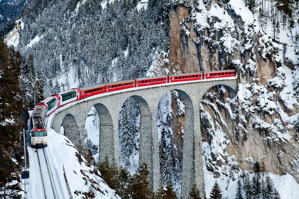 Roter Zug auf schneebedecktem Landwasserviadukt bei Filisur im Winter, Graubünden Schweiz – Jan Geerk Fotograf Basel