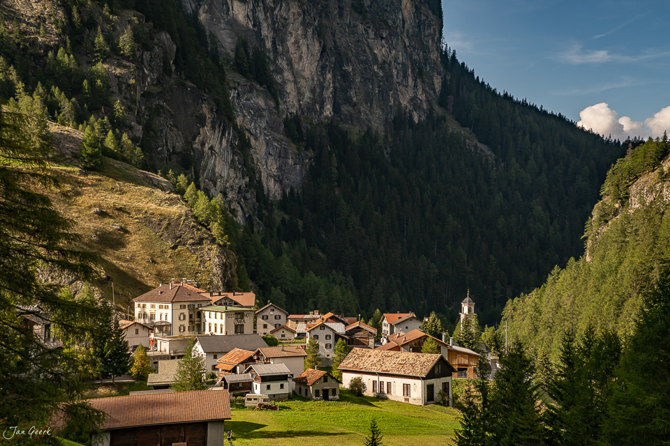 Bergdorf Mulegns im Surses Tal mit Kirche, umgeben von Felsen und Wald im Sommer – Graubünden Schweiz – Jan Geerk Fotograf Basel