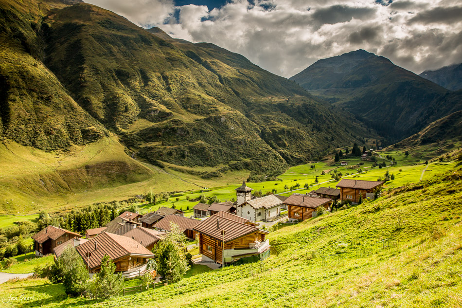 Alpendorf mit Chalets in grüner Berglandschaft, Oberalp Graubünden Schweiz – Jan Geerk Fotograf Basel