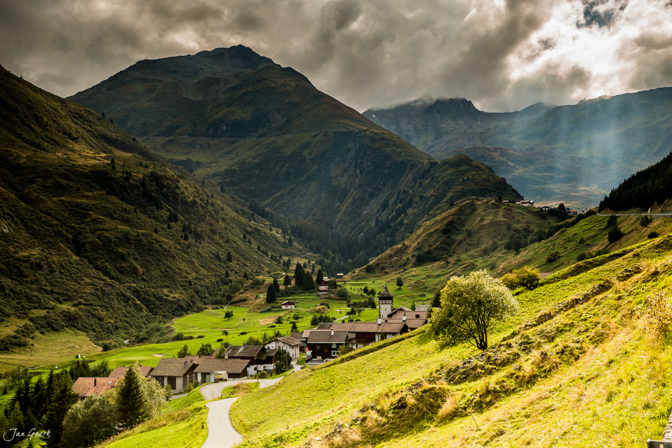 Alpendorf Oberalp mit Bergpanorama grüne Wiesen Sommerlicht Graubünden Schweiz Jan Geerk Fotograf Basel