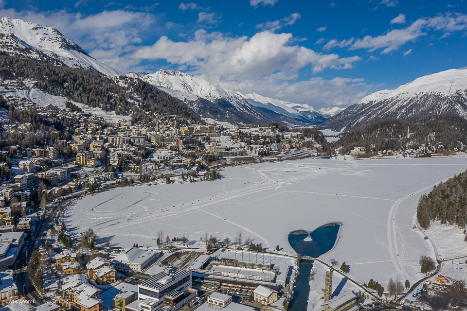 Gefrorener Bergsee mit Bergstadt und schneebedeckten Alpen im Winter, Graubünden Schweiz – Jan Geerk Fotograf Basel