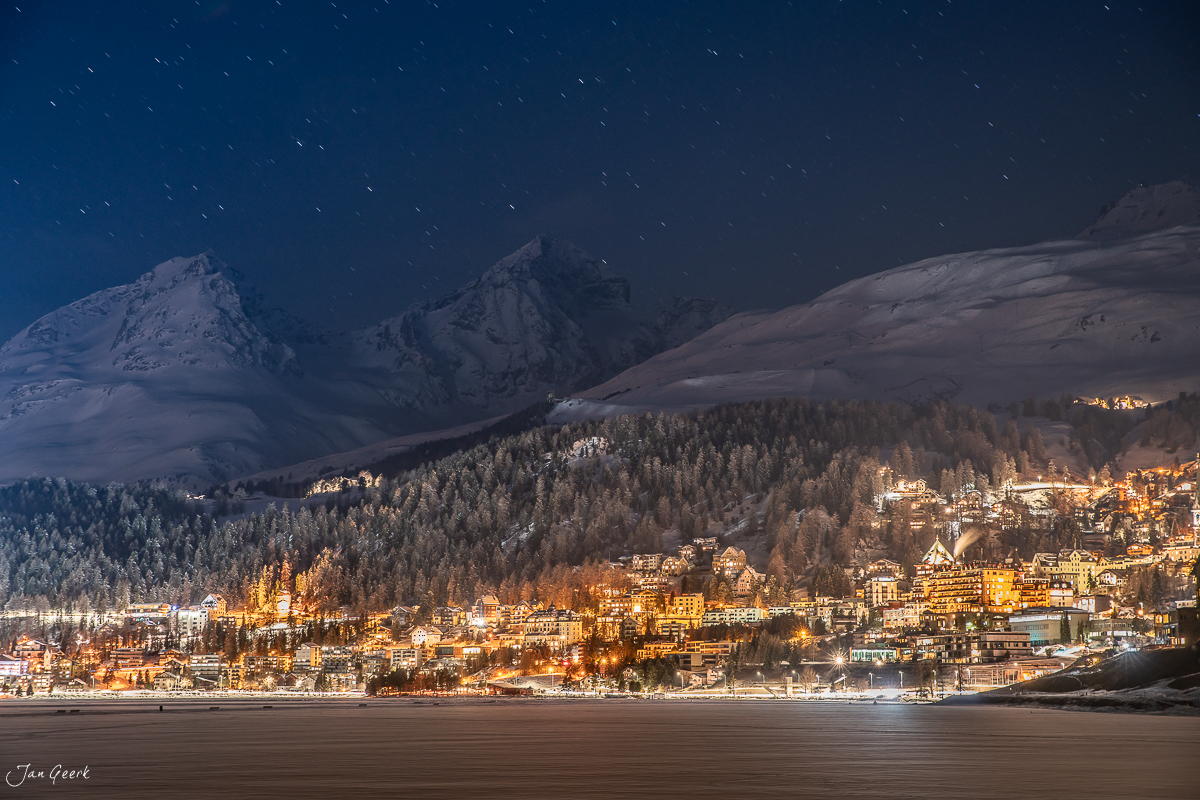 Nächtliche Bergkulisse über St. Moritz mit verschneiten Gipfeln und beleuchteter Siedlung im Winter, Graubünden Schweiz – Jan Geerk Fotograf Basel