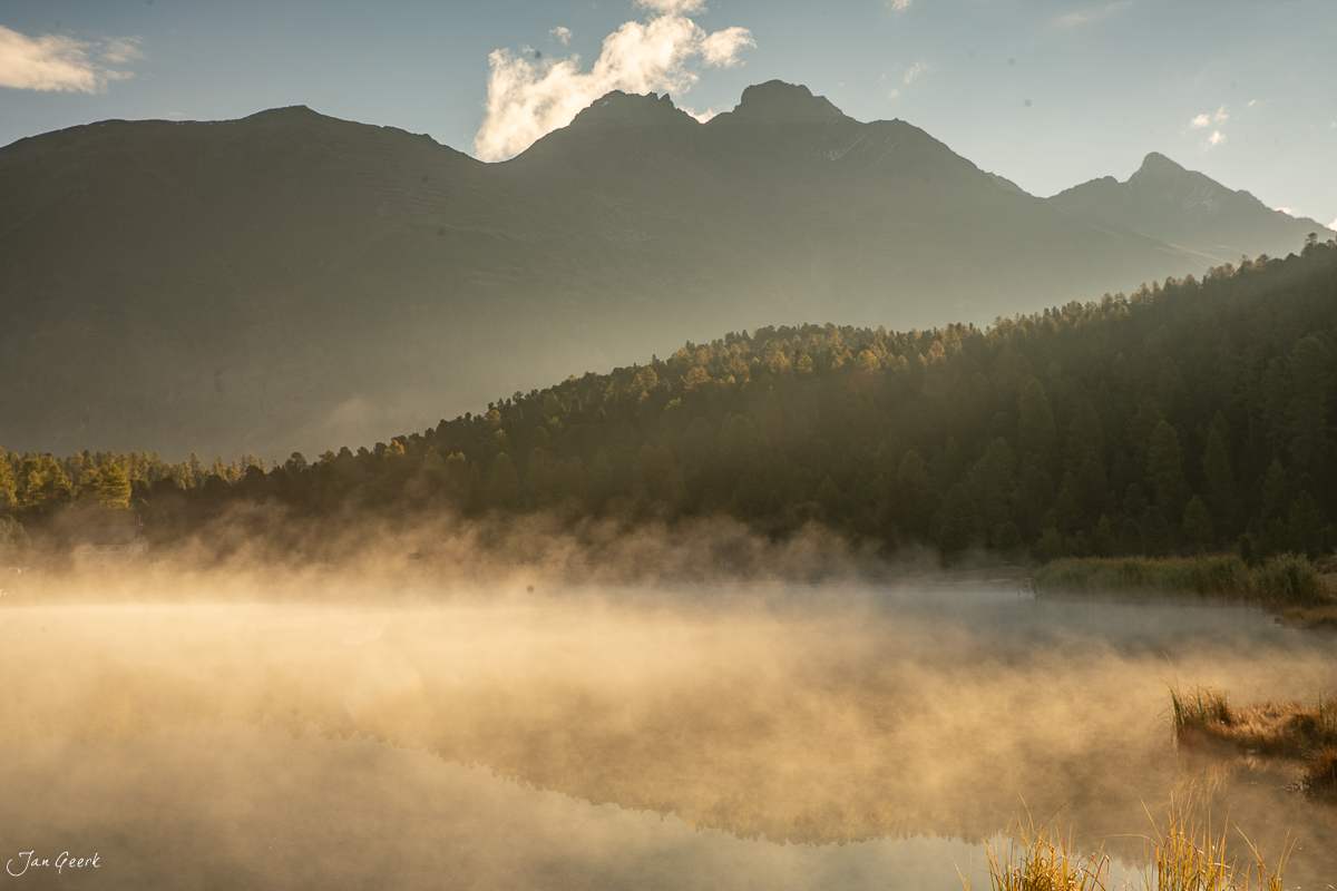 Morgennebel über dem Stazersee mit Bergkette und Lärchenwäldern im Oberengadin, Graubünden Schweiz – Jan Geerk Fotograf Basel