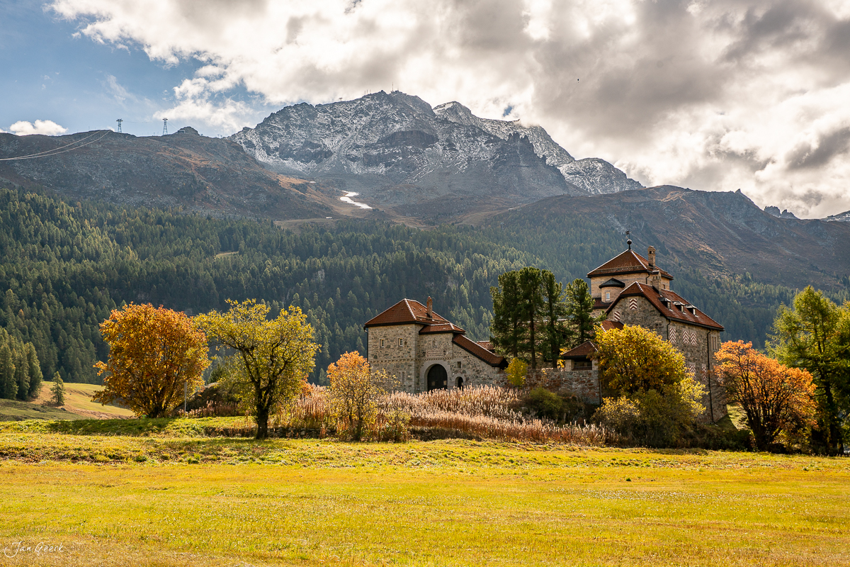 Dorfkirche mit Herbstlaub am Stazersee im Engadin mit schneebedecktem Berg, Graubünden Schweiz – Jan Geerk Fotograf Basel