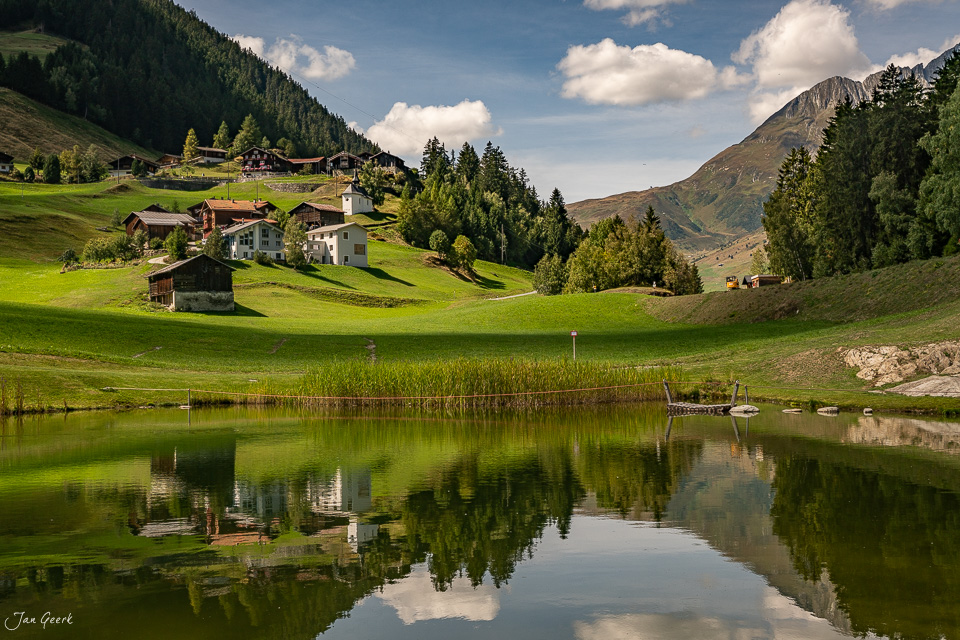 Idyllische Alpensiedlung mit See und Berge am Sedrun bei Sommerliche Lichtstimmung Graubünden Schweiz – Jan Geerk Fotograf Basel