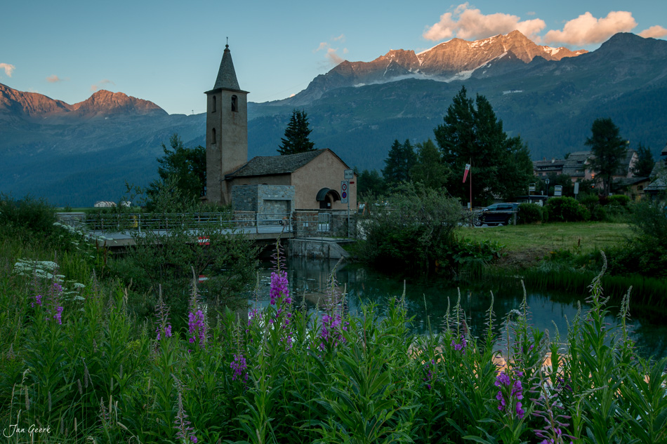 Kirche mit Kirchturm am See Sils umgeben von Bergen und Blüten im Sommer Engadin Schweiz – Jan Geerk Fotograf Basel