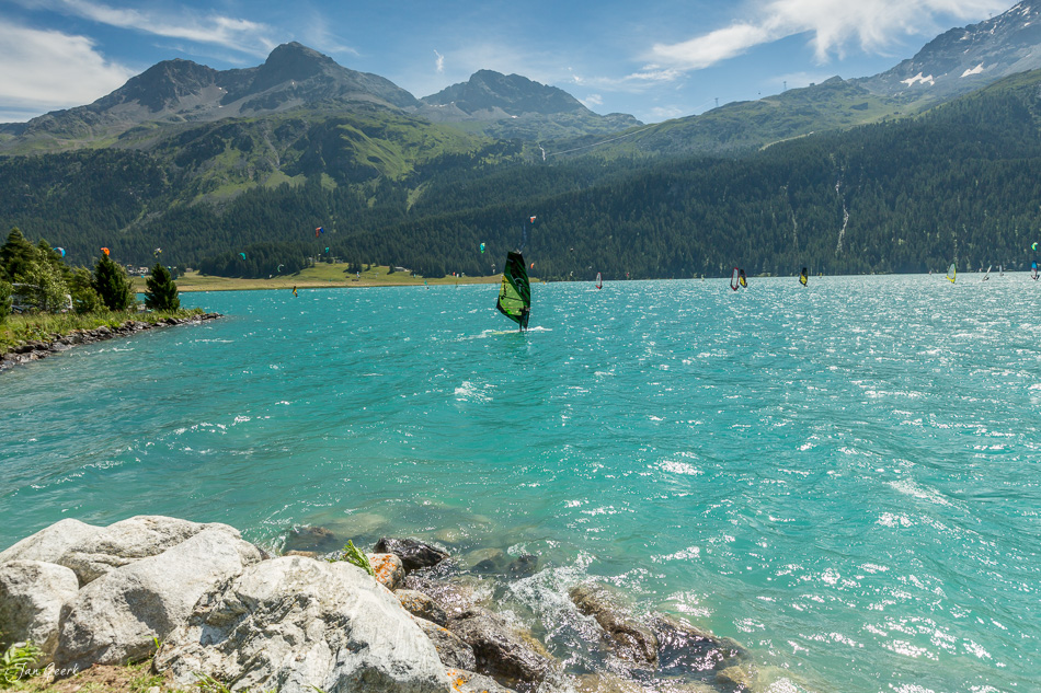 Kitesurfer und Segelboote auf dem Silvaplana See mit grünen Bergen im Sommer Engadin Graubünden Schweiz – Jan Geerk Fotograf Basel