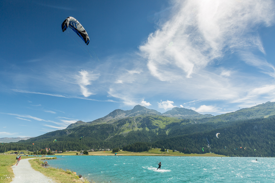 Kitesurfer auf dem glitzernden Wasser des Silvaplanasees mit Engadin-Bergkulisse im Sommer – Jan Geerk Fotograf Basel