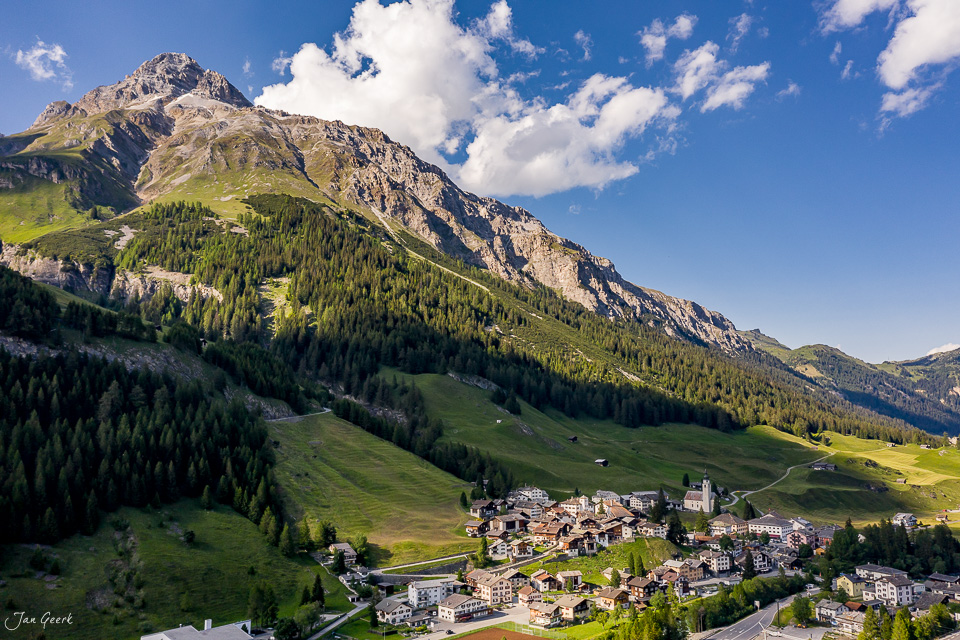 Luftaufnahme Splügen mit Berglandschaft, grünen Wiesen und Koniferen im Sommer, Graubünden Schweiz – Jan Geerk Fotograf Basel