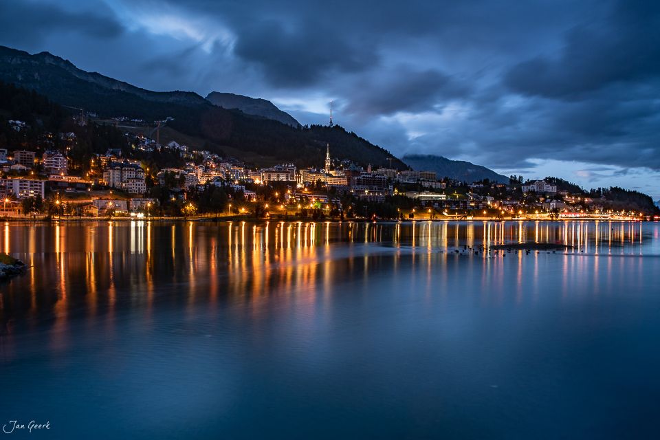 Nächtliche Seeuferszene St. Moritz mit beleuchteten Gebäuden, Bergen und Spiegelungen im Wasser – Graubünden Schweiz – Jan Geerk Fotograf Basel