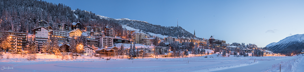 Verschneites Dorf St. Moritz mit beleuchteten Hotels am gefrorenem See, Winterlandschaft Graubünden Schweiz – Jan Geerk Fotograf Basel