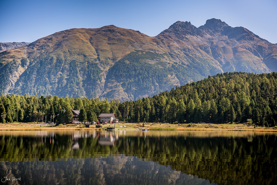 Stazersee mit Berghütten, Wald und schneebedeckten Bergen im Sommer, Engadin Graubünden Schweiz – Jan Geerk Fotograf Basel