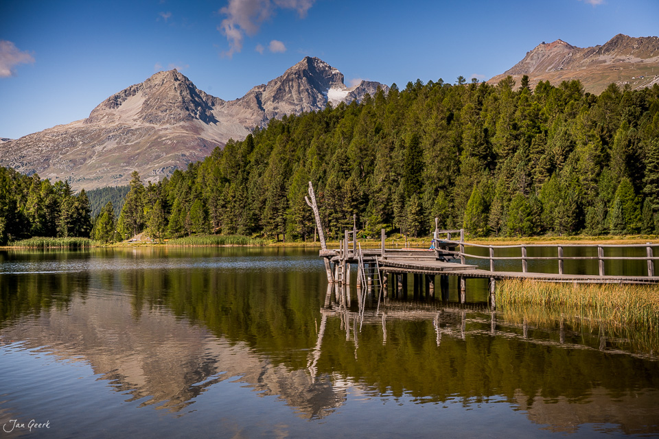Holzsteg am Stazersee mit Bergpanorama, Lärchenwälder und Spiegelungen im Sommer, Engadin Graubünden Schweiz – Jan Geerk Fotograf Basel