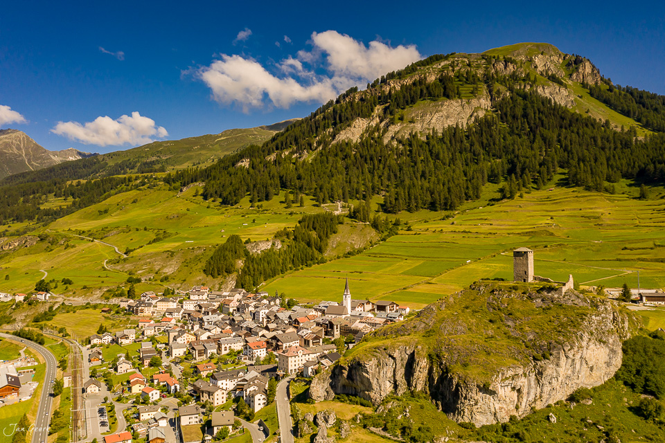 Luftaufnahme des Dorfes Ardez im Unterengadin mit Schloss Tarasp, grüne Alpwiesen und Koniferen im Sommer, Graubünden Schweiz – Jan Geerk Fotograf Basel