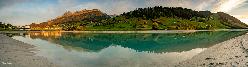Alpiner See mit Spiegelung grüner Berghänge, Brigels Graubünden Sommer, Schweiz – Jan Geerk Fotograf Basel