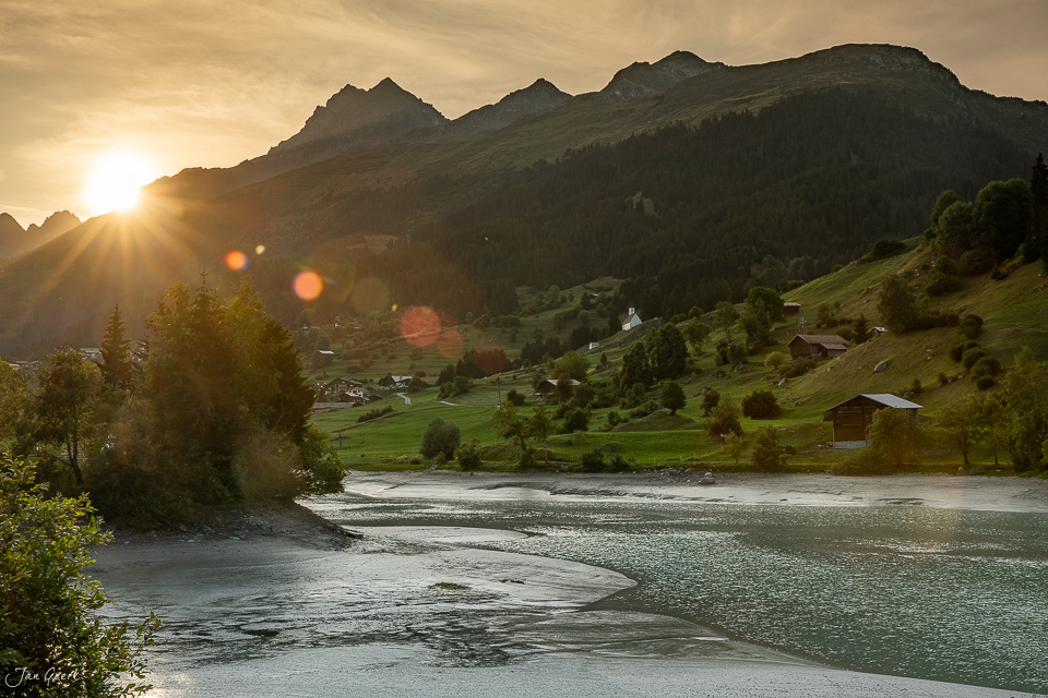 Alpendorf Brigels an der Surselva mit Fluss und Bergen bei Sonnenuntergang Sommer Graubünden Schweiz Jan Geerk Fotograf Basel