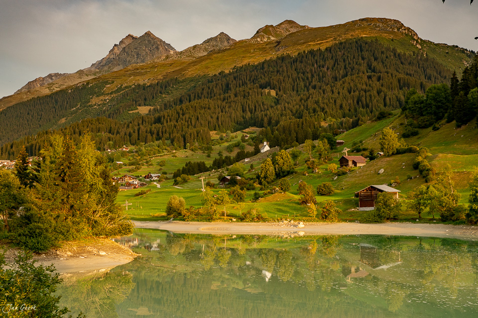 Alpendorf Brigels mit See, Lärchenwälder und Berge im Sommer, Graubünden Schweiz – Jan Geerk Fotograf Basel