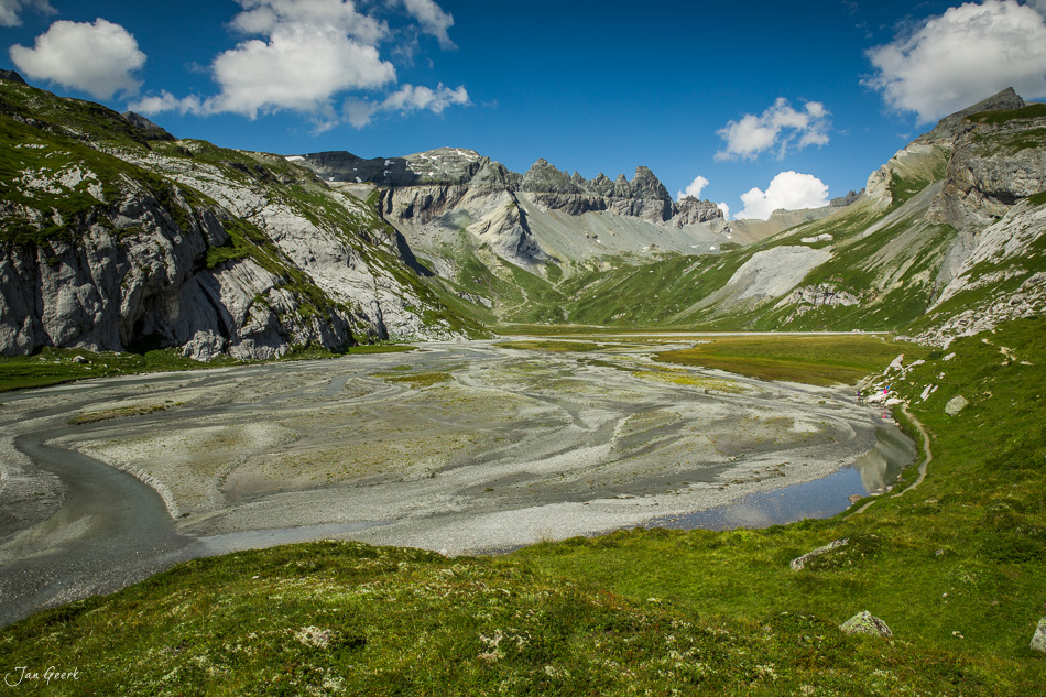 Segnesboden Alpenmulde mit Fluss und Tschingelhörner Bergkette unter blauem Himmel, Graubünden Schweiz – Jan Geerk Fotograf Basel
