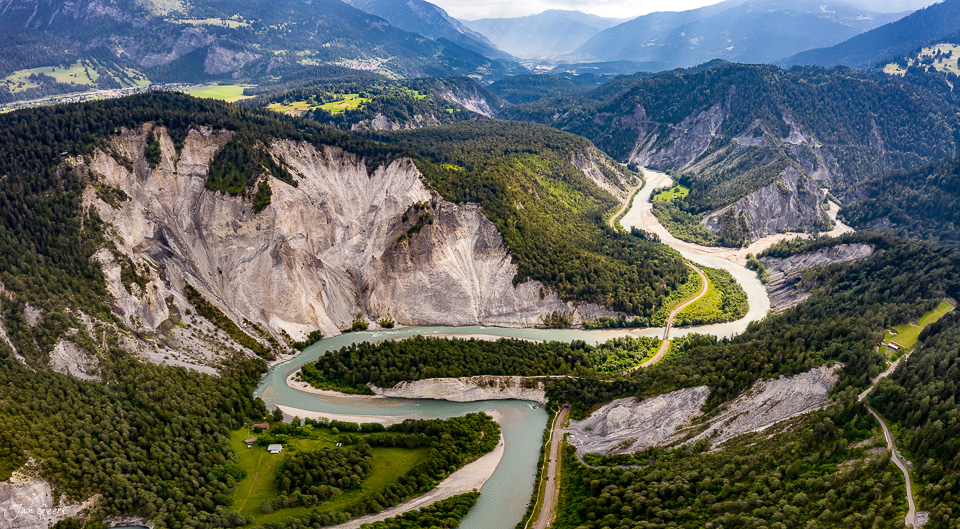 Luftaufnahme der Rheinschlucht mit mäanderndem Fluss, grünen Wäldern und hellen Felswänden in Graubünden Schweiz – Jan Geerk Fotograf Basel