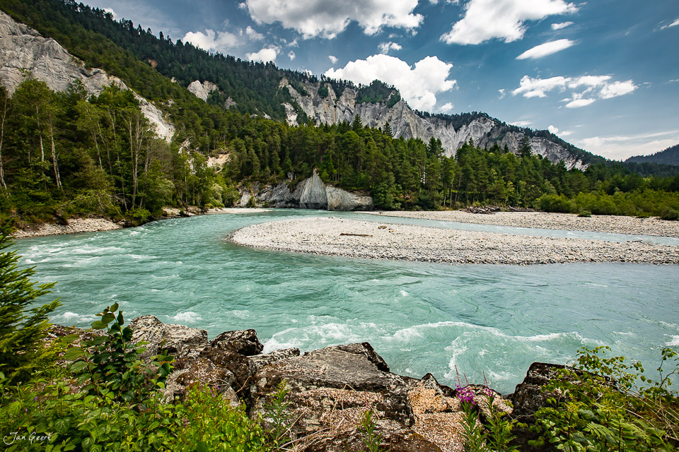 Türkisfarbener Fluss in der Rheinschlucht mit Kalksteinfelsen und Nadelwald unter blauem Himmel, Graubünden Schweiz – Jan Geerk Fotograf Basel