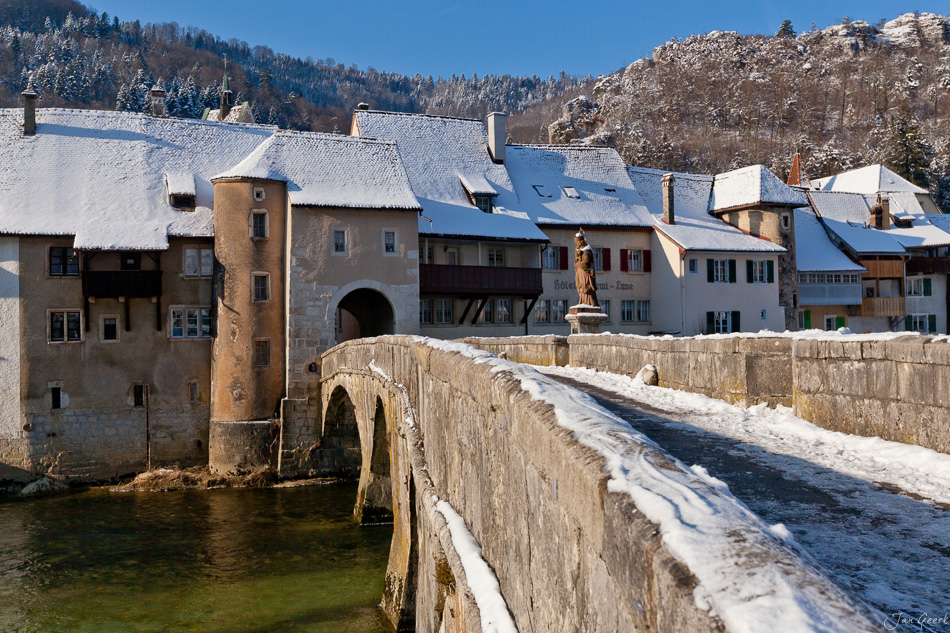 Schneebedeckte Steinbrücke mit Wehrgebäude Dorf Franches-Montagnes Winter Jura Schweiz – Jan Geerk Fotograf Basel