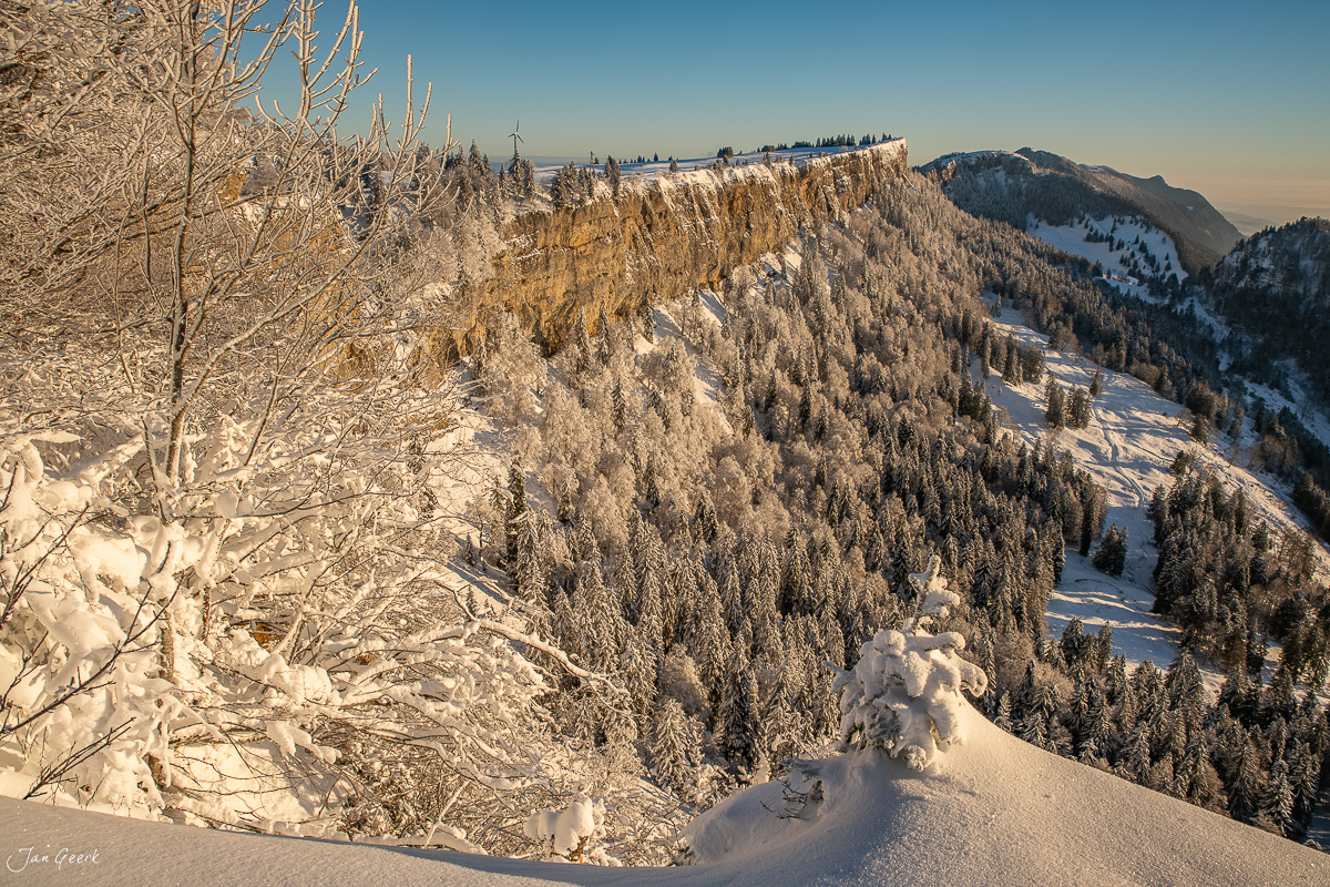 Schneebedeckte Wandfluh mit Reifbäumen bei Sonnenaufgang, Grenchenberg, Schweiz – Jan Geerk Fotograf Basel