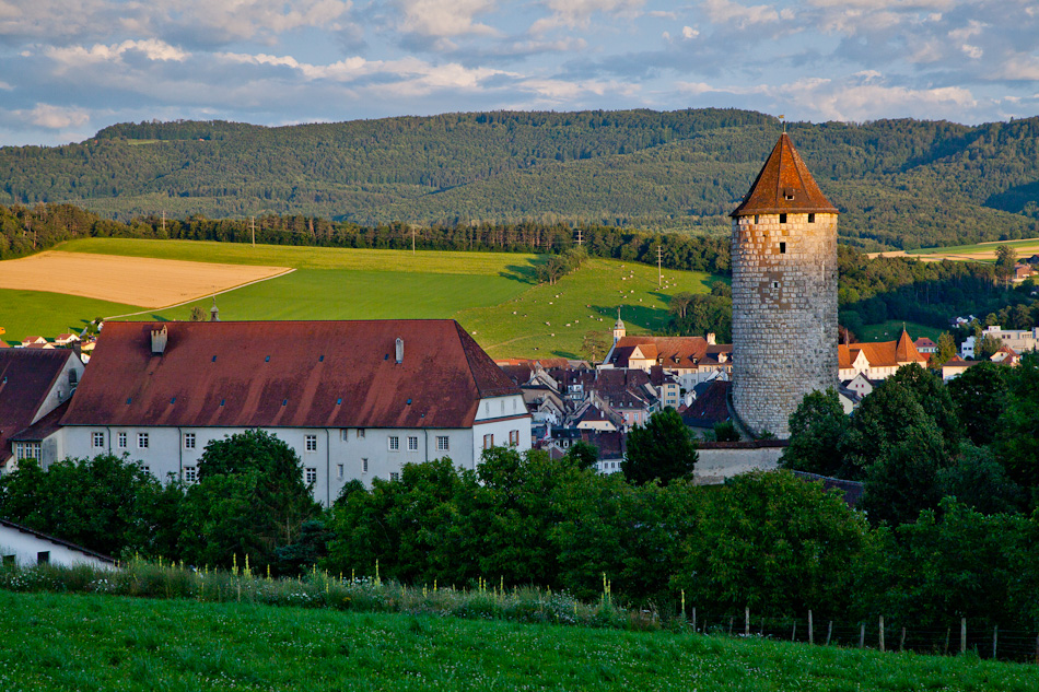 Schloss Porrentruy mit Wehrturm, grüne Jura-Landschaft, Sommerlichtstimmung, Schweiz – Jan Geerk Fotograf Basel