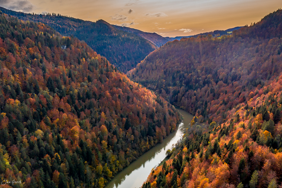 Herbstliches Flusstal mit Laubwald und Gebirgsfluss im Jura, goldene Herbststimmung Schweiz – Jan Geerk Fotograf Basel