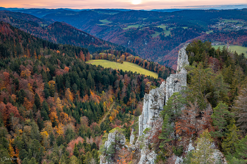 Felsenformation und Herbstwald im Jura mit goldenen Blättern und Tal bei Sonnenuntergang Schweiz Jan Geerk Fotograf Basel