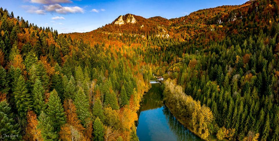 Herbstlandschaft mit Fluss und bewaldeten Bergen in der Schweiz – Jan Geerk Fotograf Basel