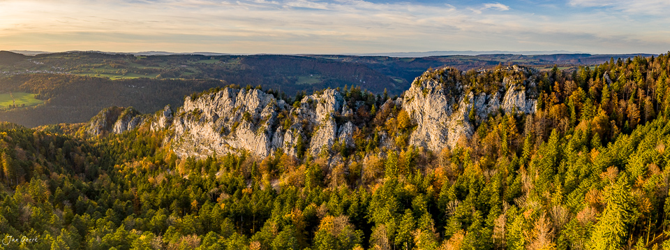 Herbstwald mit Kalkfelsen im Jura bei Saignelégier, Luftaufnahme in Kantlicht, Schweiz – Jan Geerk Fotograf Basel