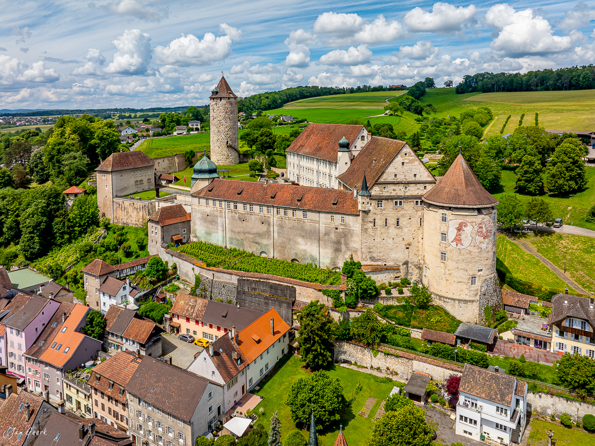 Schloss Porrentruy mit Turm und Wehranlagen, grüne Jurallandschaft, Sommertag, Luftaufnahme, Schweiz – Jan Geerk Fotograf Basel